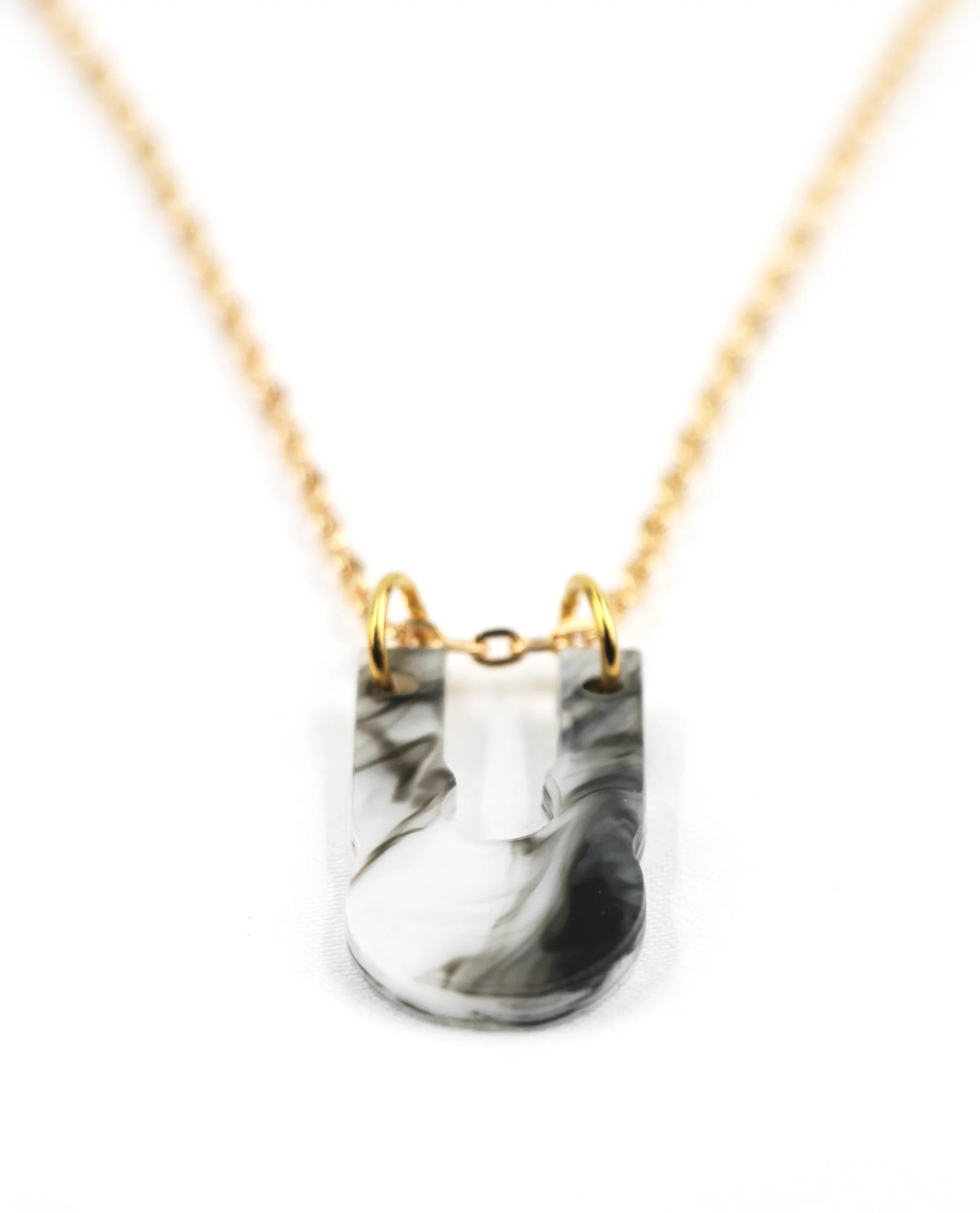 Collar dorado con colgante marmolado blanco y negro
