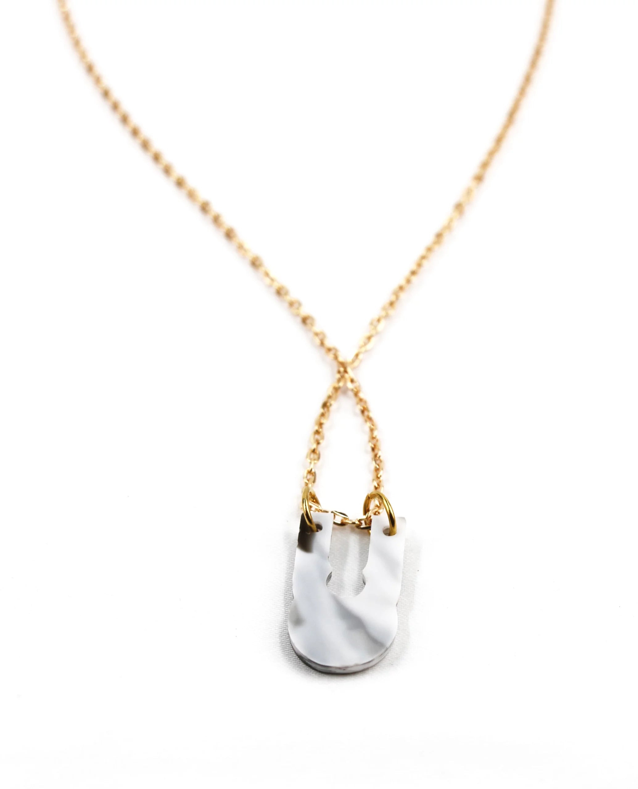 Collar dorado con colgante marmolado blanco y negro